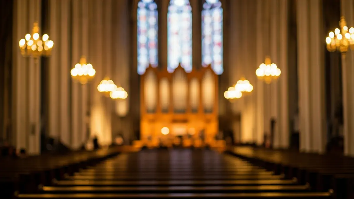Imagen de un órgano de tubos en el interior de una catedral, con luz cálida y vidrieras al fondo.