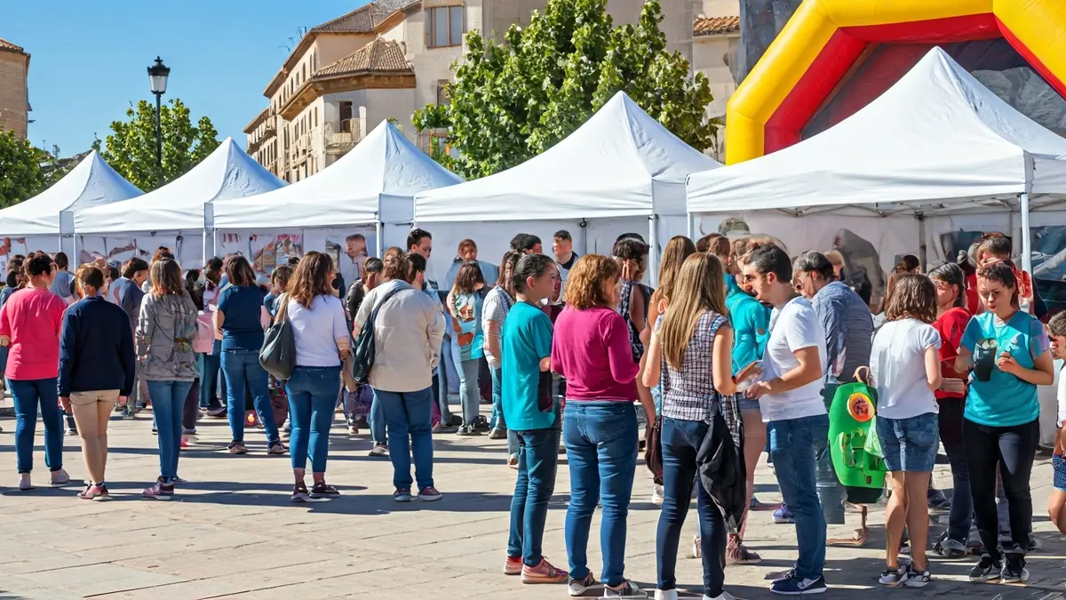 Image of a health fair with tents and activities in a town square.