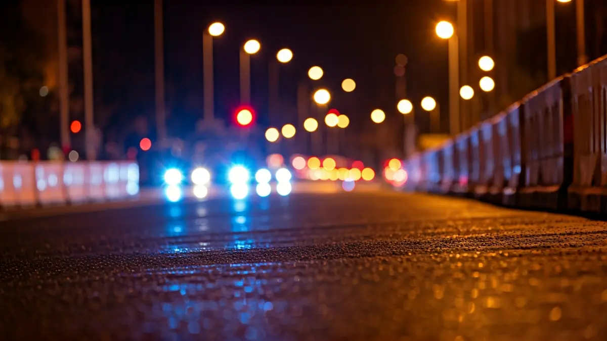 Imagen genérica de luces de emergencia en una carretera de noche, con barreras de construcción.