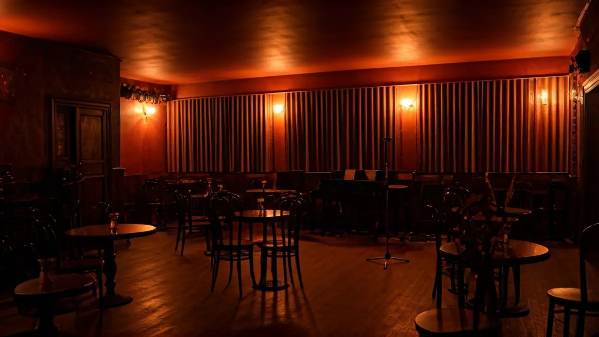 Generic image of a jazz club with an empty stage and seating, lit with warm lights.