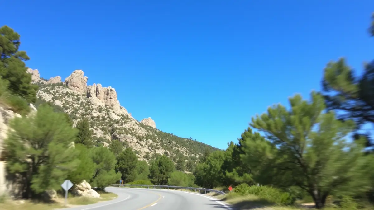 Carretera de montaña en la Sierra de Madrid, con curvas y vegetación.