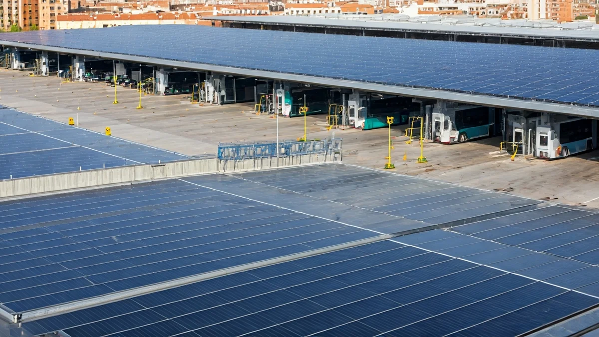 Imagen de un centro de operaciones de autobuses con paneles solares y puntos de recarga eléctrica.