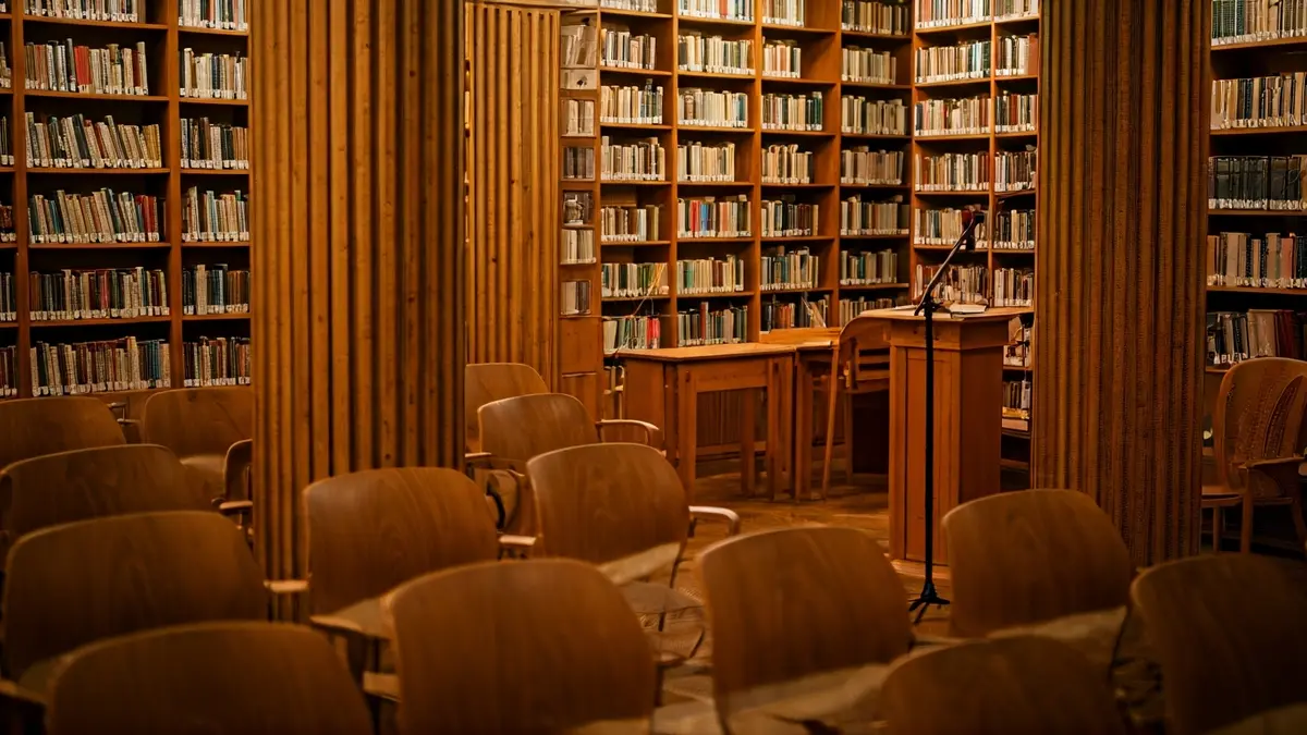 Imagen genérica de una biblioteca con un podio y sillas, iluminada cálidamente.
