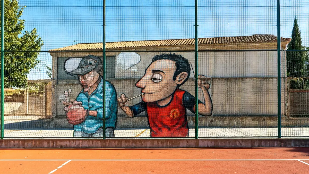 Urban art mural on a fronton wall featuring characters from the Torrente saga.