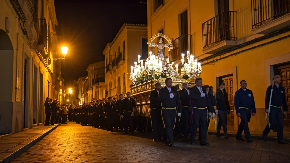 Imagen genérica de una procesión religiosa en una calle histórica al anochecer.