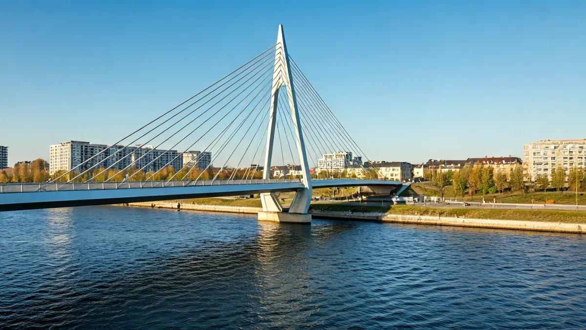 Image of a modern pedestrian bridge over a river and a highway, with contemporary architectural design.