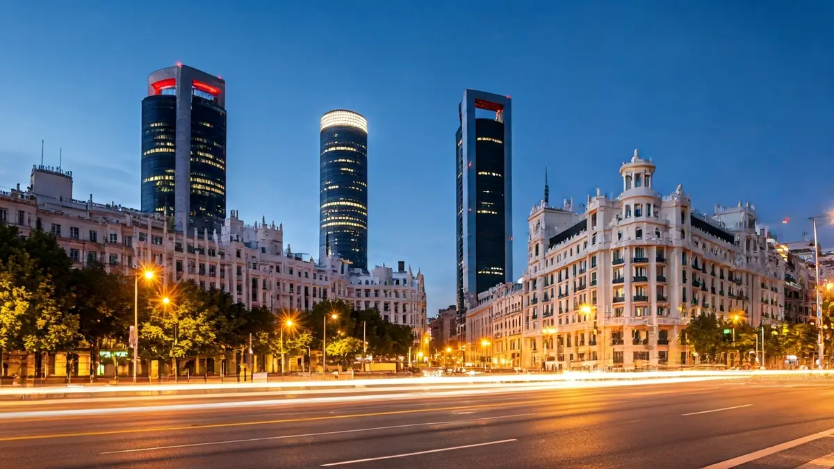 Aerial view of Madrid city at dusk, with modern buildings and urban lights.
