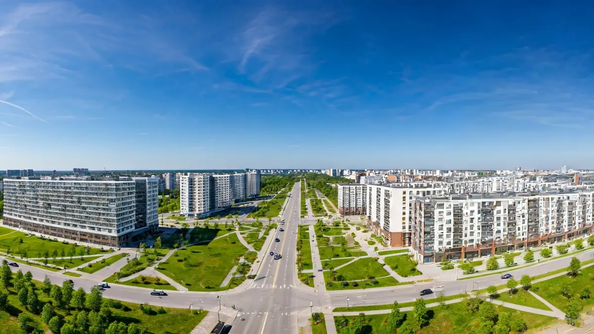 Vista aérea de un desarrollo urbano moderno con edificios residenciales y zonas verdes.