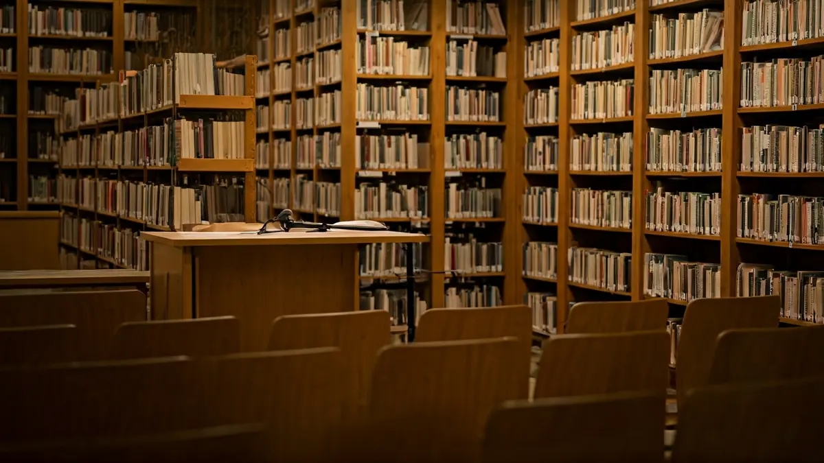 Imagen genérica de un interior de biblioteca o sala de exposiciones con iluminación cálida.