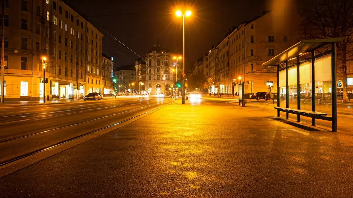 Generic image of an empty bus stop shelter at night in a European city.