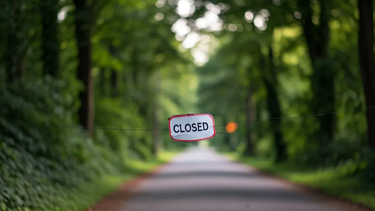 Imagen de la entrada de un parque con un cartel de 'cerrado'.