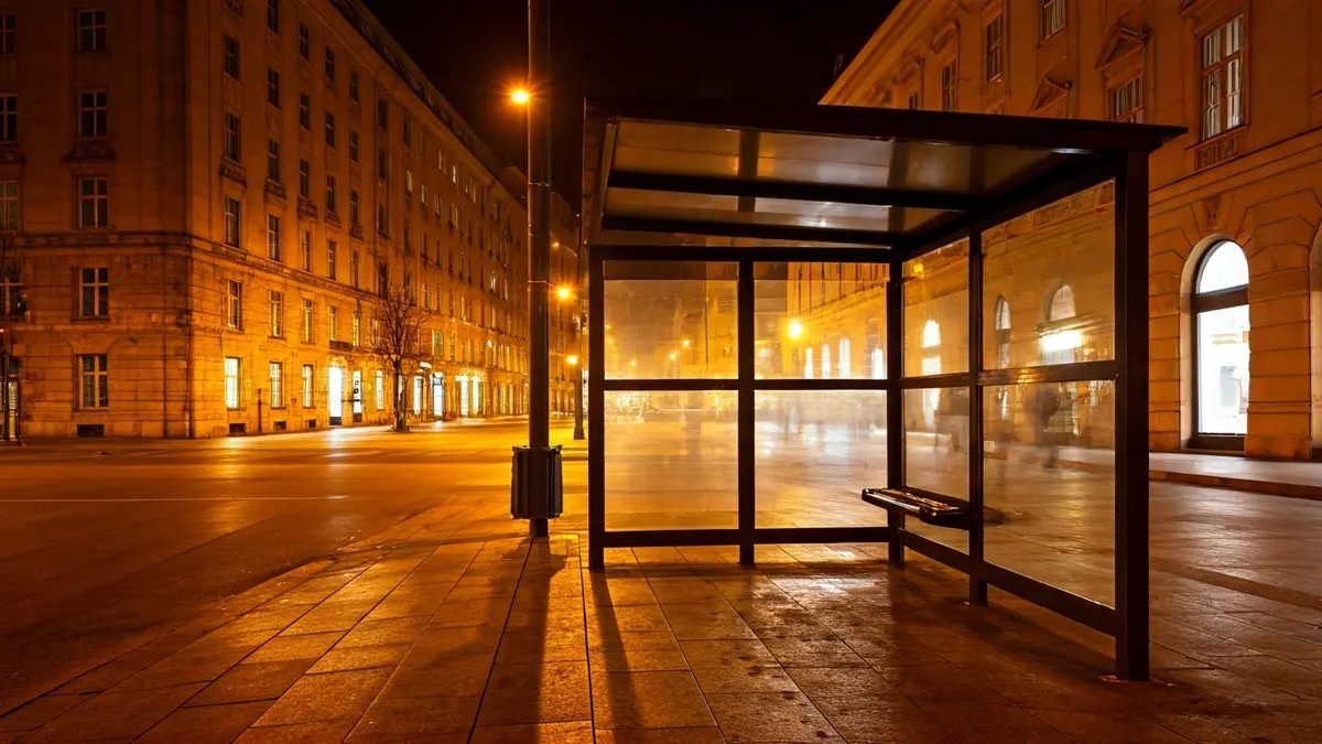 Imagen genérica de una parada de autobús vacía por la noche, con luces de la calle.