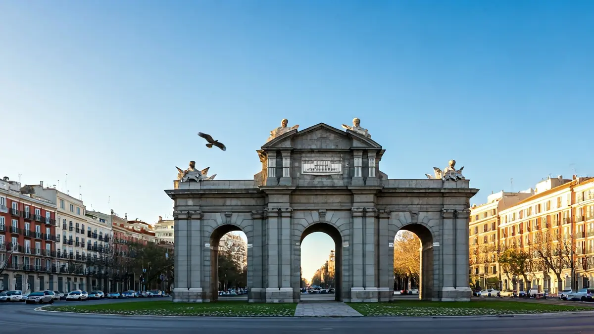 La Puerta de Alcalá en Madrid, con un ave rapaz volando en la distancia.