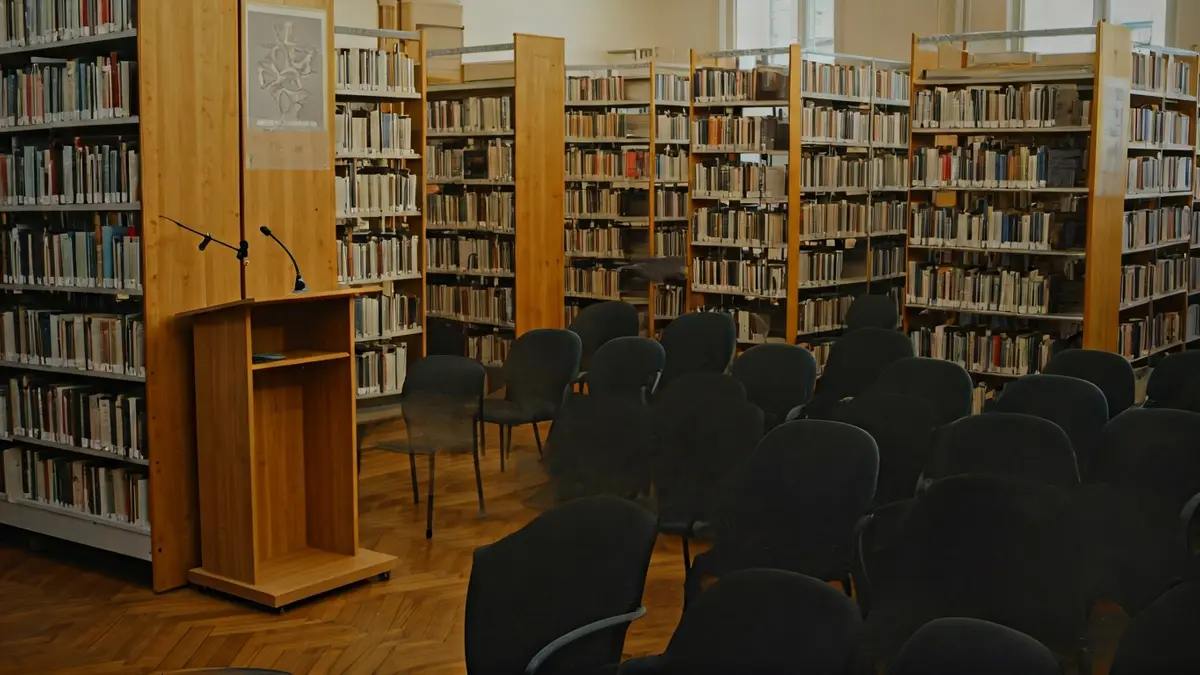 Imagen genérica de una biblioteca con estanterías de madera y un podio con micrófono.