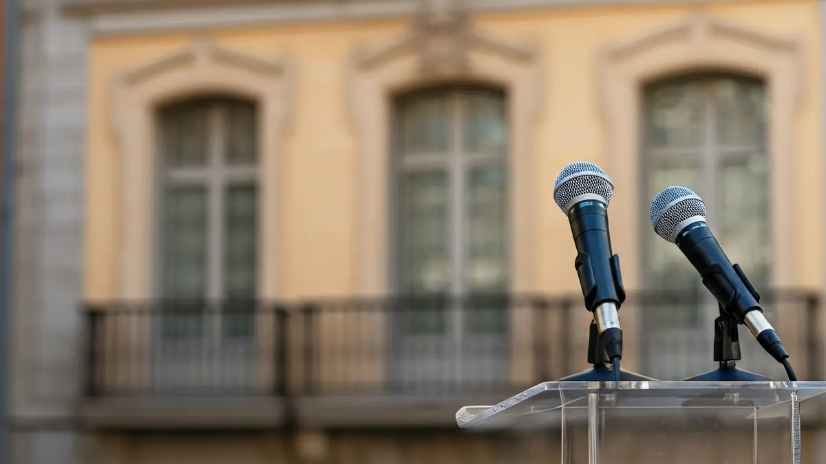 Generic image of a microphone on a podium, with a historic balcony in the background.