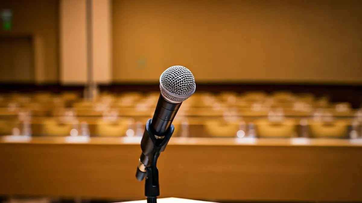 Generic image of a microphone on a podium in a conference room.