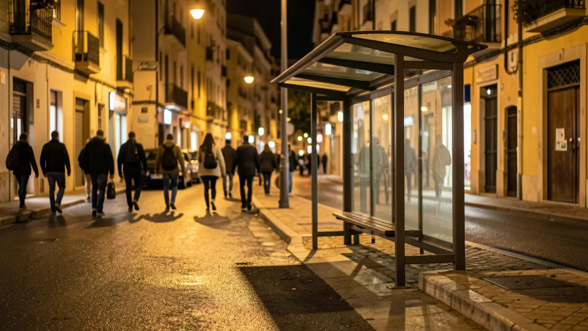 Imagen genérica de una parada de autobús vacía por la noche con luces de calle cálidas.