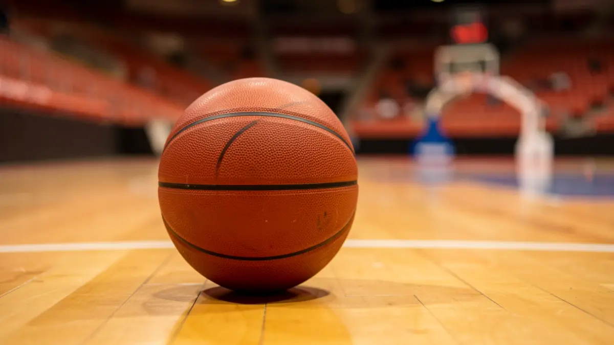 Generic image of a basketball on a wooden court.