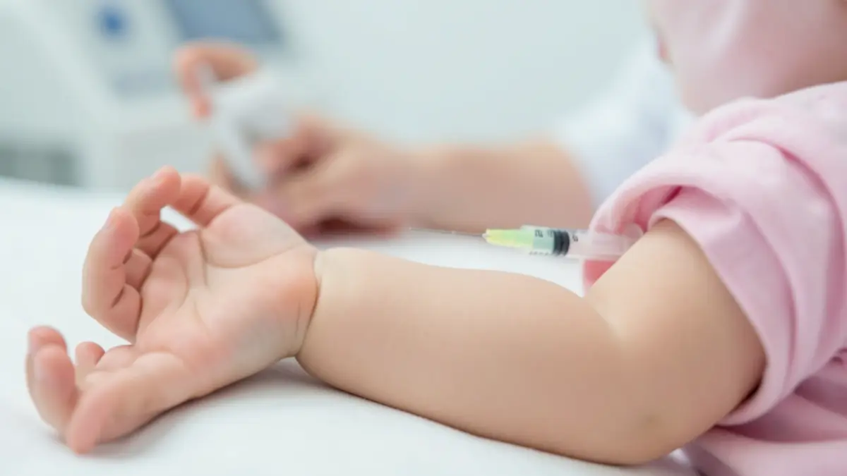Image of a baby receiving a vaccination in the arm.