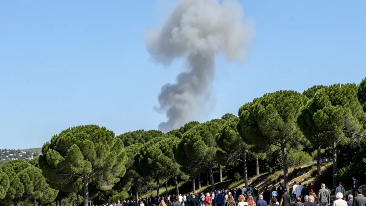 Generic image of a column of smoke rising over a pine forest hillside.