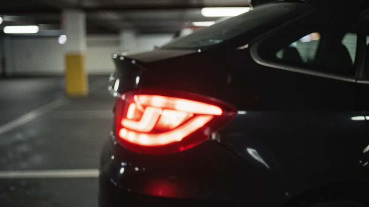 Blurred security camera footage of a parking lot showing a damaged car.