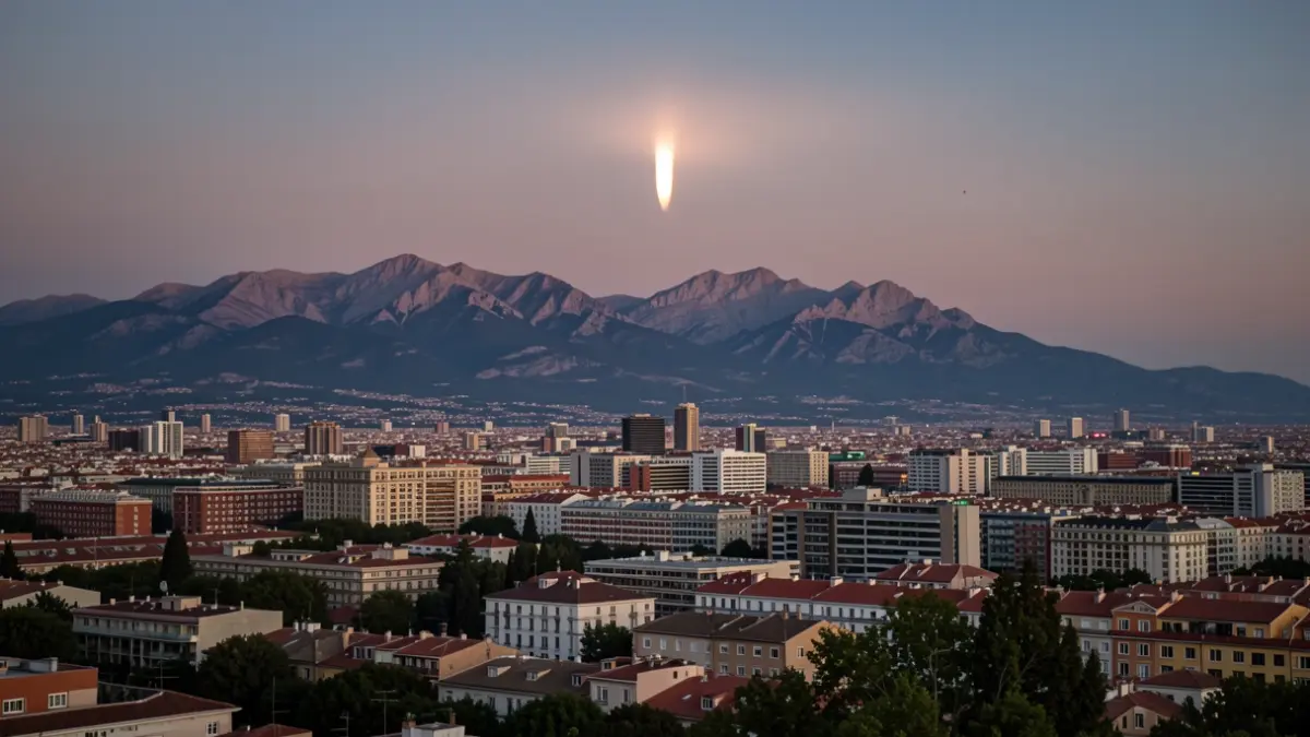 Panoramic view of the Madrid skyline and the Sierra de Guadarrama mountains from Paracuellos de Jarama at sunset, with the beginning of a solar eclipse.