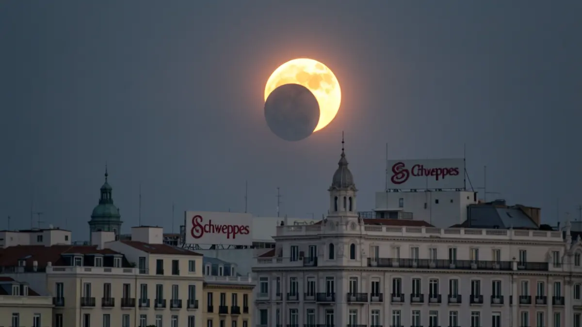 Image of the solar eclipse seen over the Madrid skyline, featuring iconic buildings like the Edificio Carrión and the Schweppes sign.