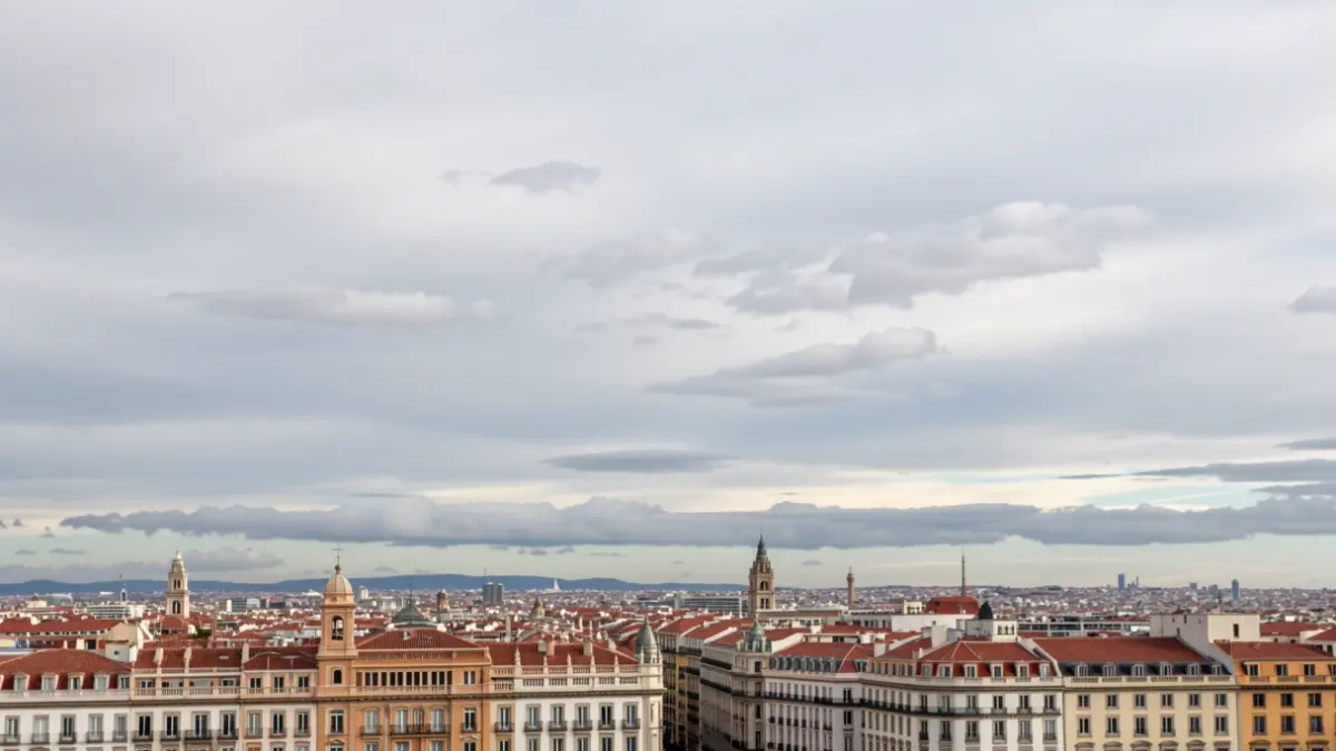 Cielo nublado sobre el perfil urbano de Madrid con nubes altas y bajas.