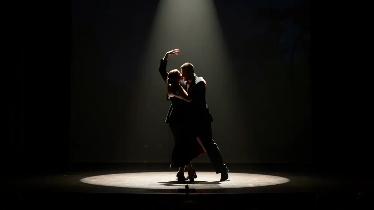 Imagen genérica de un escenario de teatro con un bailarín de tango bajo un foco de luz.