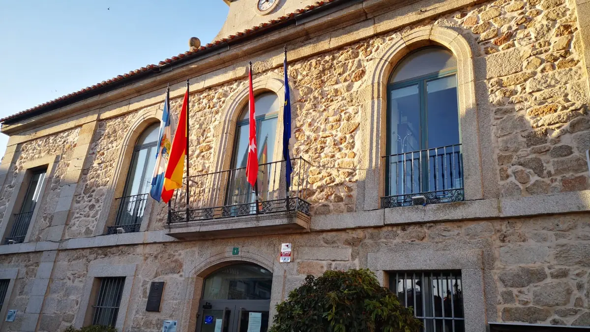 Facade of the Valdemorillo Town Hall with balcony and iron railings, under the afternoon sunlight.